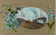 Rail trucks and two large ships berthed at Railway Pier (Station Pier), Port Melbourne, pre-December 1907. This is a greeting card with sprays of flowers on either side of the image.
