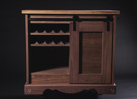 olid wood cabinet featuring bottle racks and a decorative base.