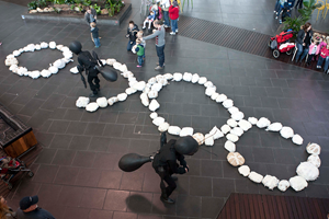 Children and ants arranging bread crumb replicas into rings.