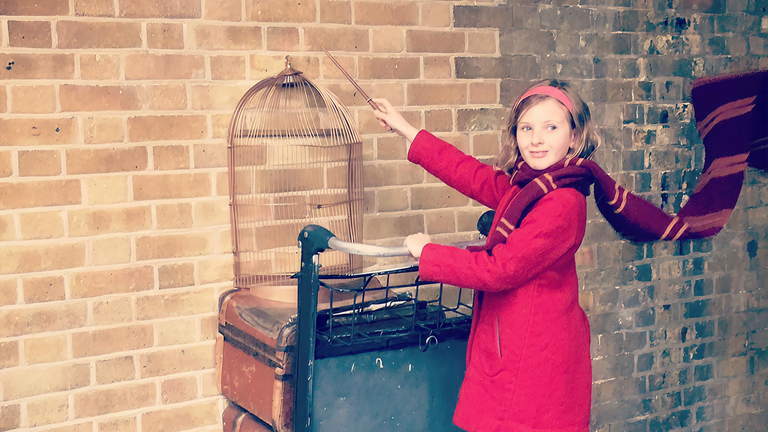 Girl walking through platform 9 and three quarters on her way to Hogwarts school of witchcraft and wizardry.