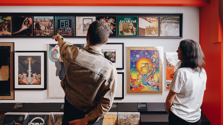 Two people view a record collection