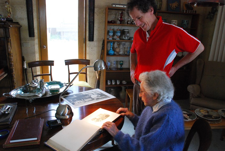 Will Twycross and his mother Mary, 2008, looking at an album of photographs surrounded by objects purchased by Will's great grandfather, John Twycross, at Melbourne's International Exhibitions.