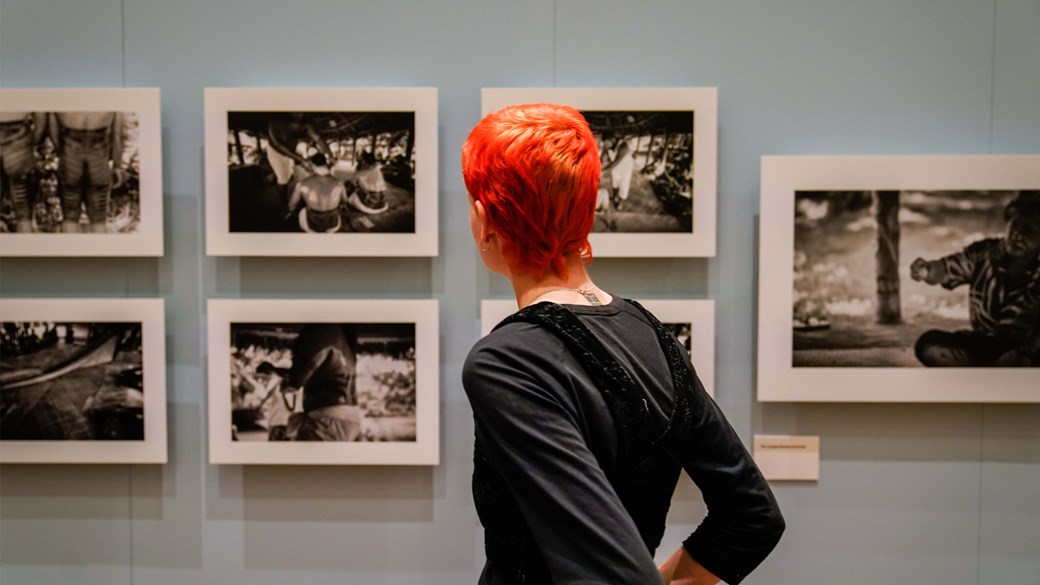 Woman with short cropped red hair looking at black and white photographs