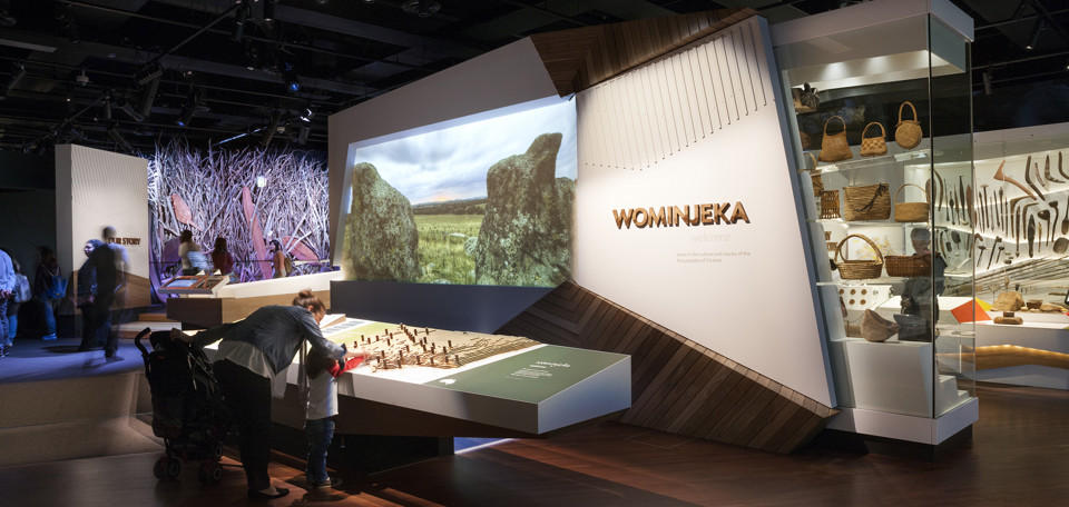 Exhibition entry with visitors looking at language map