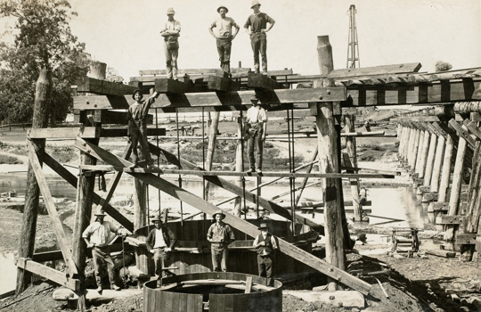 Construction of Pier 3 of the Tambo River Bridge on the Bairnsdale to Orbost line, 1914. The outer timber form for the concrete pour is in place.