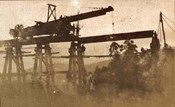 Trestle bridge under construction on the Warragul to Noojee line, post-1910. A travelling crane is sitting on the bridge and appears to be lowering a girder into position.