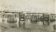 Construction of the Mitchell River Bridge, Bairnsdale, on the Bairnsdale to Orbost line, circa 1914. The road bridge over the Mitchell River is in the foreground.