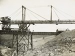 A travelling crane is lowering a girder in the last span of the Maribyrnong River Viaduct on the Albion to Broadmeadows line, Keilor East, 1928.