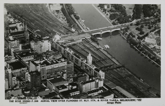 Aerial view of Flinders Street Station with the Yarra River, Princes Bridge and many commercial buildings, post-1930