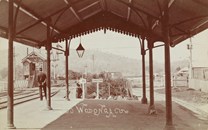 A guard stands on the platform of Wodonga Railway Station as a train approaches, circa 1910