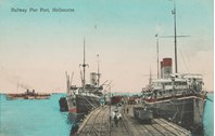 Railway track leading into Railway Pier, Port Melbourne, pre-17 September 1911. Some carriages on train line. A number of ships moored at pier. Some people walking along pier