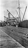 Loading grain from rail trucks to ships at pier, Portland, 1921
