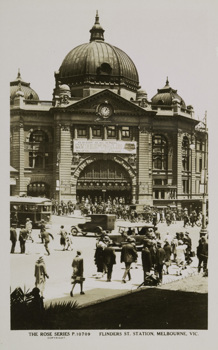 A large banner advertising Mt Buffalo Chalet spans the front of Flinders Street Railway Station, circa 1920