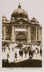 A large banner advertising Mt Buffalo Chalet spans the front of Flinders Street Railway Station, circa 1920