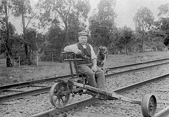 A ganger and a dog sitting on a ganger's trolley, Hastings district, circa 1920