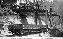 Construction staff dumping ballast into railway trucks on the Bairnsdale to Orbost line, 1914