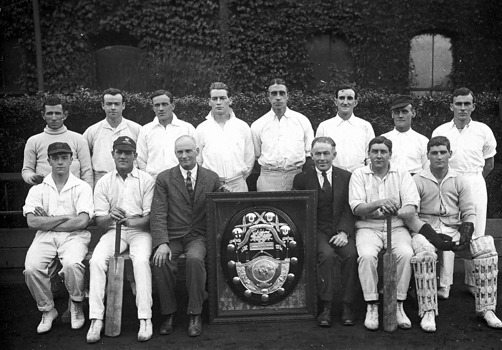 Members of the Victorian interstate railway workshop cricket team and a large, framed trophy, Newport, 1922