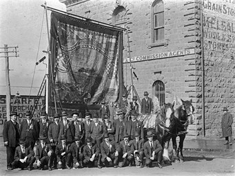 Members of the Ballarat branch of the Victorian Railways Union with their banner aloft, Ballarat, Eight Hours Day, 1913