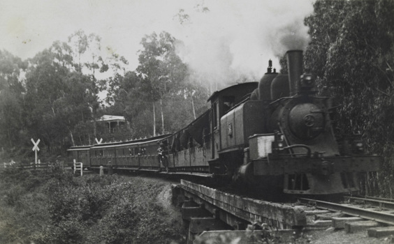 Steam locomotive hauling passenger carriages, circa 1920