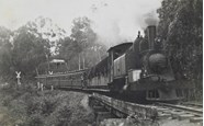 Steam locomotive hauling passenger carriages, circa 1920