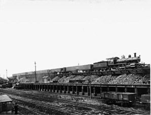 V class steam locomotive with 2-8-0 wheel arrangement and Oo class coal wagons, North Melbourne, circa 1900