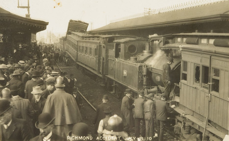 Train crash at Richmond Railway Station, 18 July 1910. Steam engine no. 494 with passenger carriages attached has run into the back of another passenger train at the platform.