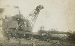 A large crane lifting an overturned steam engine, circa 1910