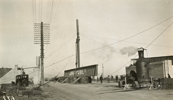 Construction of the Dynon Road rail bridge on the South Kensington to West Footscray line, Kensington, 1928. A crane is about to lift the first 112 ft girder into position.