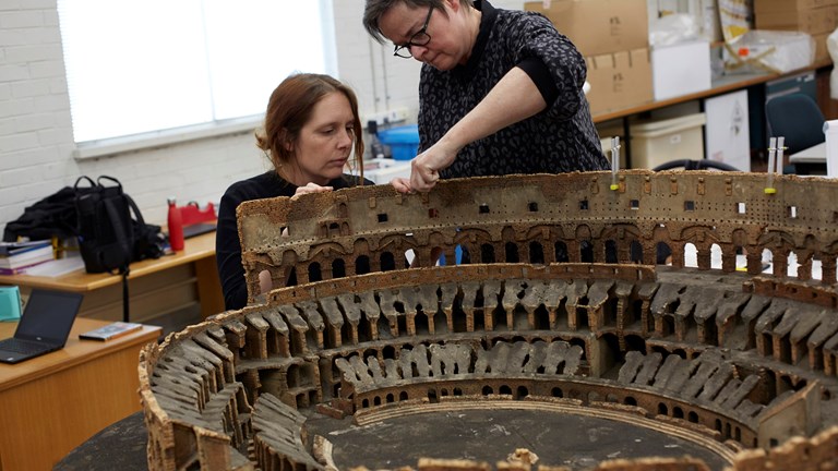 Conservators Sarah Babister and Penny Byrne preparing the Roman Colosseum model made of cork by Richard Du Bourg (or Dubourg), London, circa 1800, before it goes on display in Melbourne Museum.
