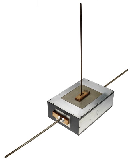 A rectangular, aliminium box with protruding measuring tape. 