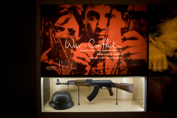 Leaving Home exhibition in Immigration Museum showing Motivations wall - War & Conflict 