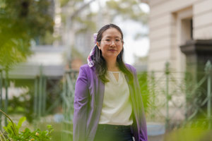Portrait of Michelle Chen standing outside under trees.