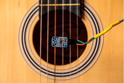 Detail of Acoustic Guitar Soundhole and Strings with Autotuner