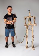 Boy Standing next to and Attached to A.T.O.M. Humanoid Robot 