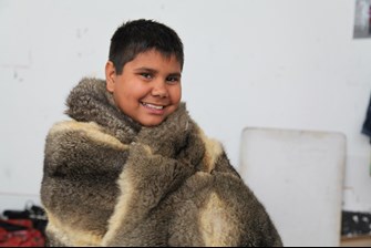 A member of the Naghlingah Boorais project wearing a possum skin cloak