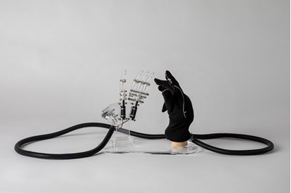 An Actuating Prosthetic Hand connected to an Actuating Prosthetic Hand covered with a Glove