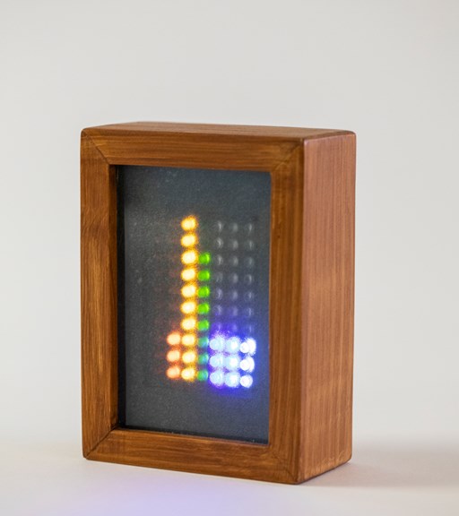Closeup of small wooden box filled with yellow, green and blue LED's being activated