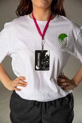 Person wearing white T-shirt and a staff lanyard, that are both branded with the 'Nights of Frights' event brand identity