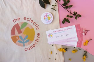 Photograph of branded tickets, tote bag and badge for 'The Eclectic Collective'. The branding is a circular logo consisting of colourful shapes and flower petals are scattered around the objects