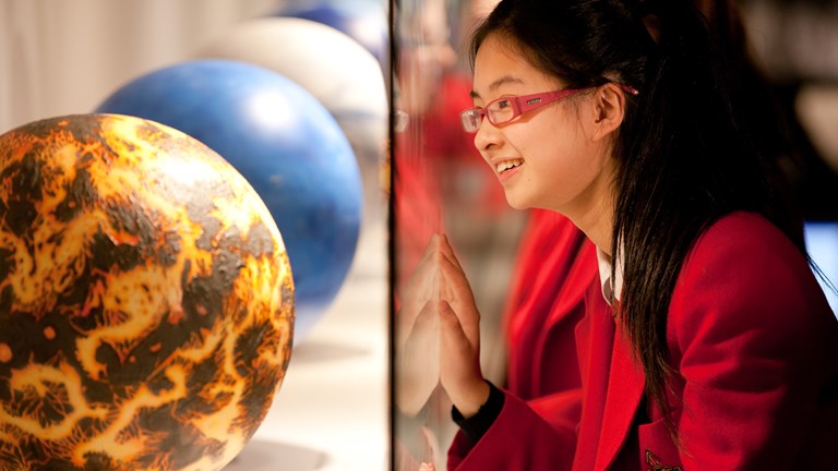 Girl looking at Earth models on display in Dynamic Earth