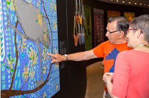 Artist Ted Laxton discussing a painting with a Museums Victoria staff member at the Pitcha Makin Fellas' Open Your Eyes exhibition launch
