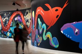 People walk by the mural at the opening of the River of Language exhibition in the Birrarung Gallery, Bunjilaka