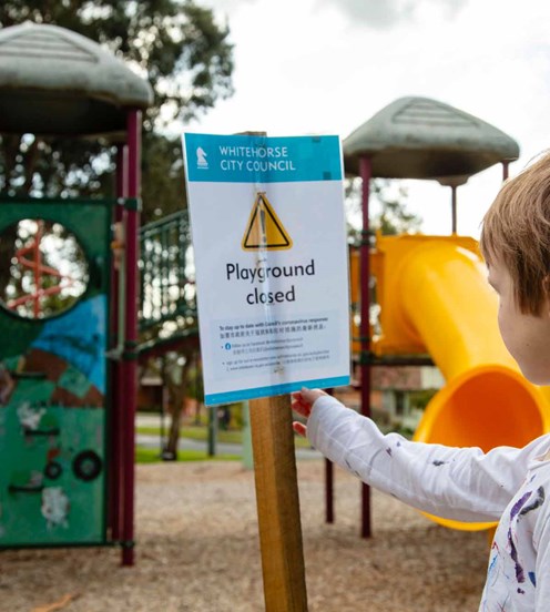 Child reading a sign in a playground
