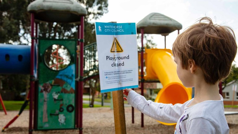 Child reading a sign in a playground
