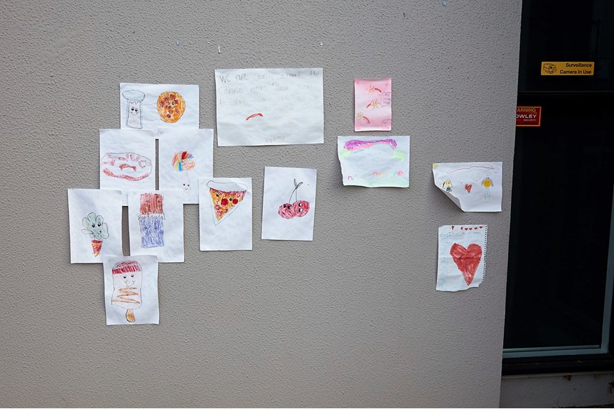 Children's drawings pinned to a wall