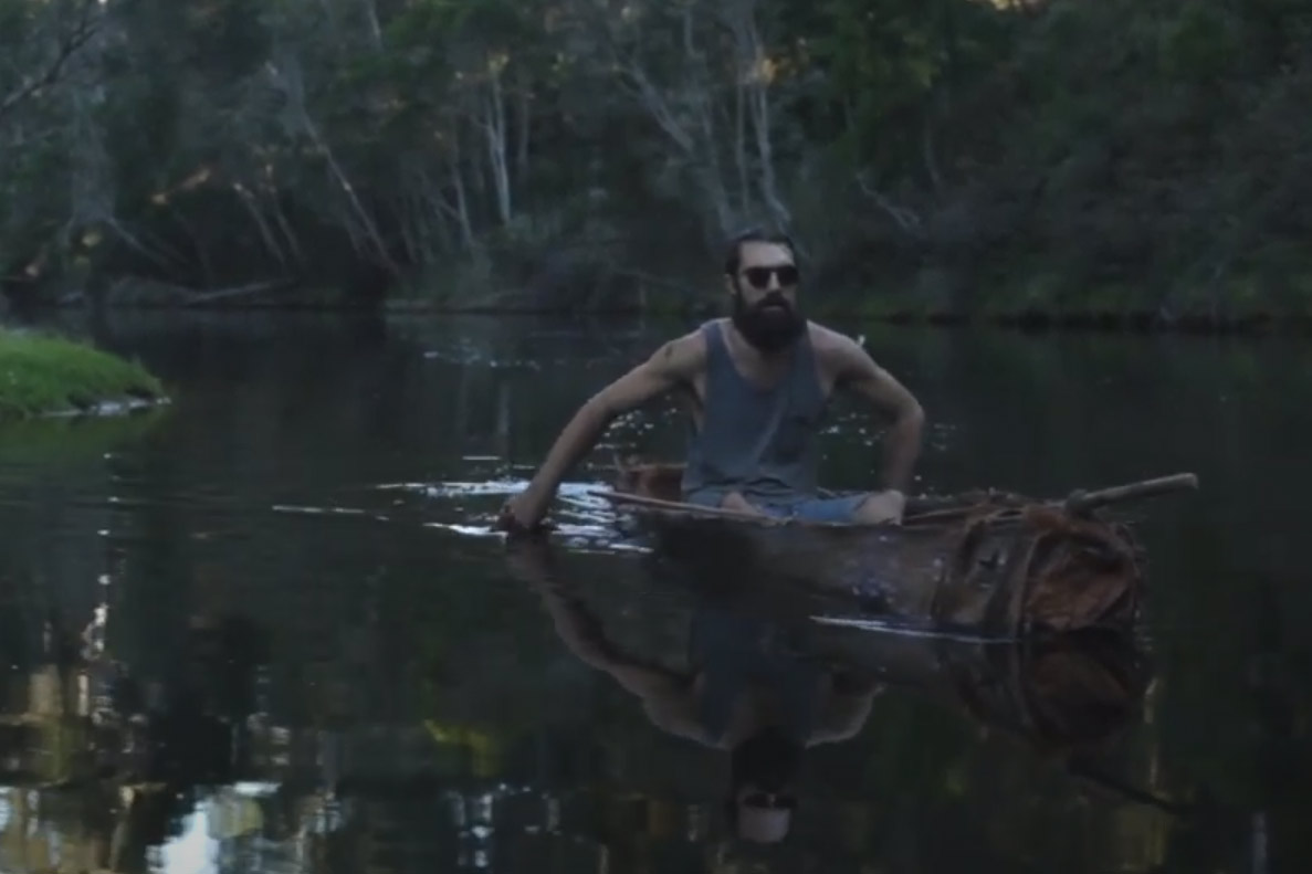 Man in a bark canoe on a river