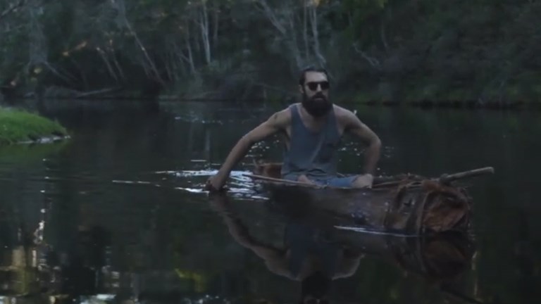 Man in a bark canoe on a river