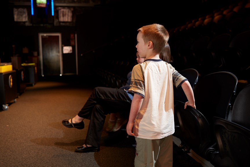 Boy leaning on chair inside the Lightning room