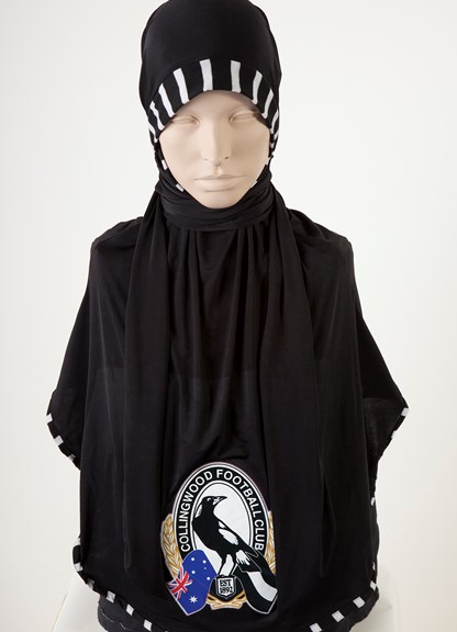 A black head covering with a magpie logo.