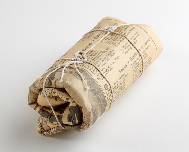 A newspaper tightly bound in an ovalish-shape. 
